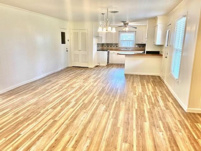 kitchen with a peninsula, white cabinetry, light wood-style floors, open floor plan, and pendant lighting