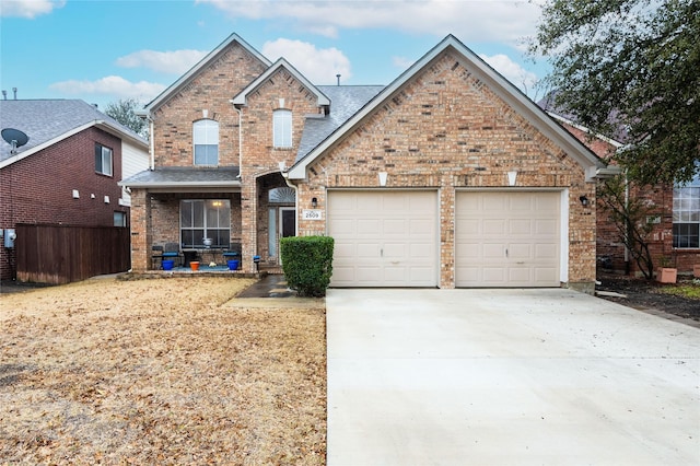 traditional-style home with a garage, concrete driveway, and brick siding