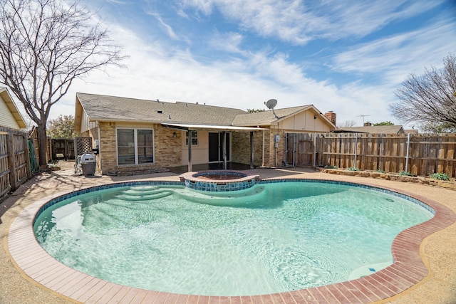 view of pool with a fenced backyard, a pool with connected hot tub, and a patio