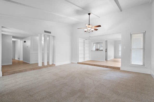 unfurnished living room featuring carpet floors, visible vents, lofted ceiling with beams, and baseboards