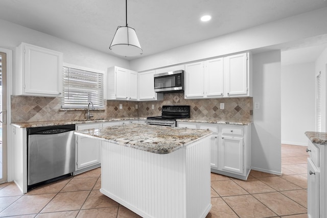 kitchen with light tile patterned floors, appliances with stainless steel finishes, a sink, and white cabinets