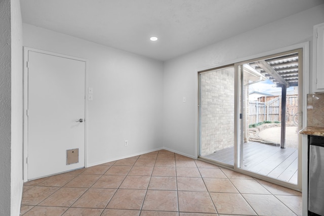 empty room featuring recessed lighting, light tile patterned flooring, and baseboards