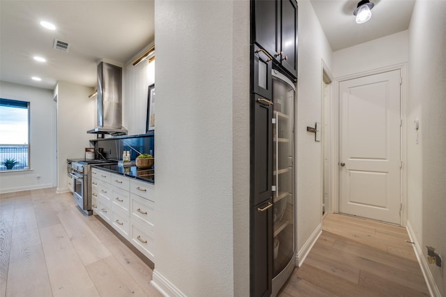 hall with light wood finished floors, visible vents, recessed lighting, and baseboards