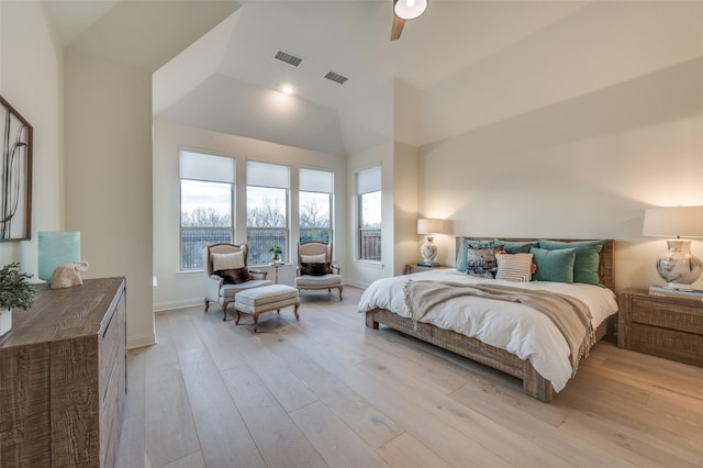 bedroom featuring visible vents, a ceiling fan, lofted ceiling, and light wood-style floors