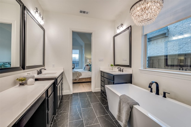 ensuite bathroom with visible vents, two vanities, a sink, connected bathroom, and a freestanding bath