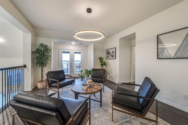 living area with visible vents, french doors, baseboards, and wood finished floors