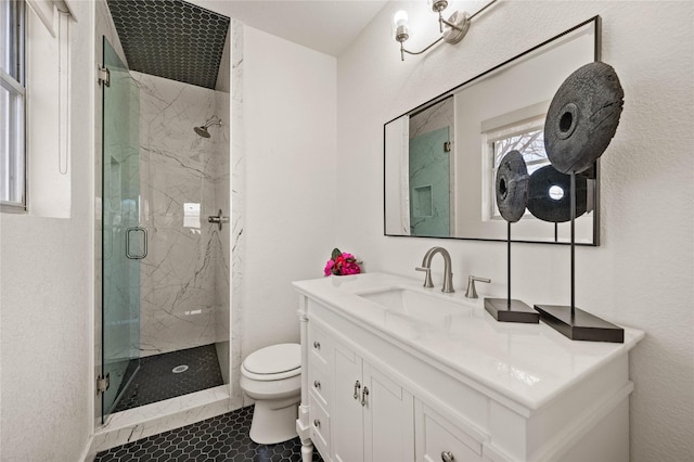 bathroom with toilet, vanity, and a marble finish shower