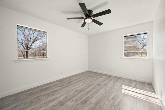 spare room featuring ceiling fan, baseboards, and wood finished floors