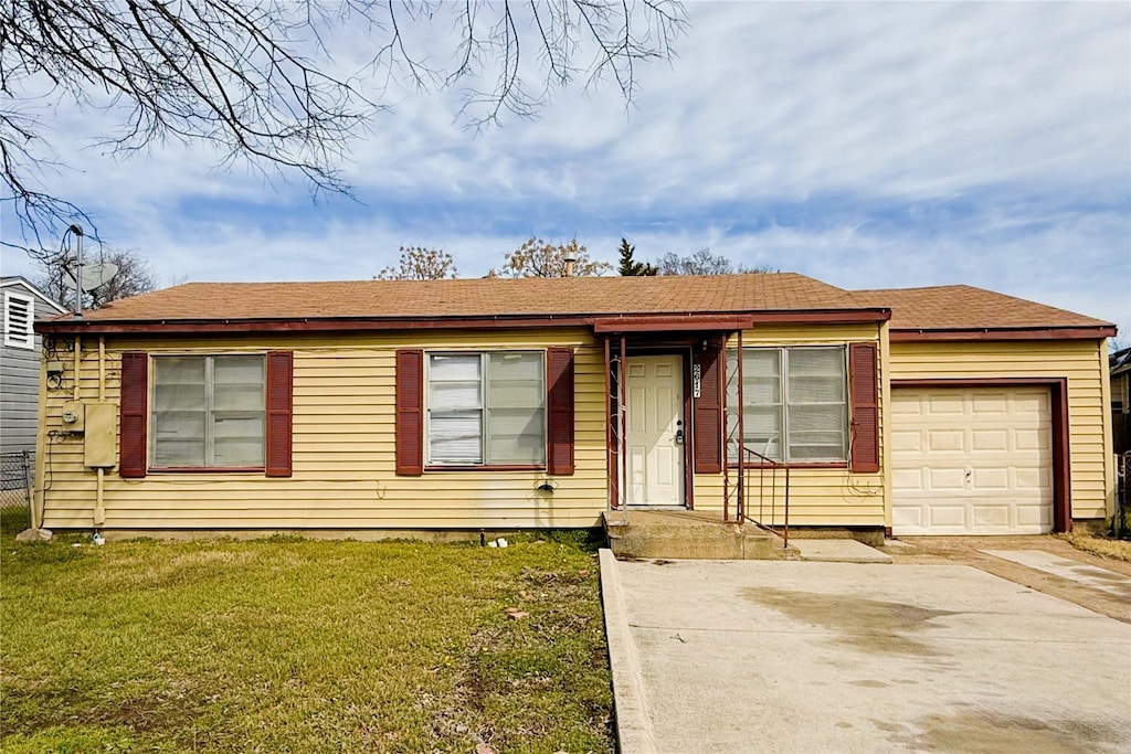 view of front of home with an attached garage, driveway, and a front yard