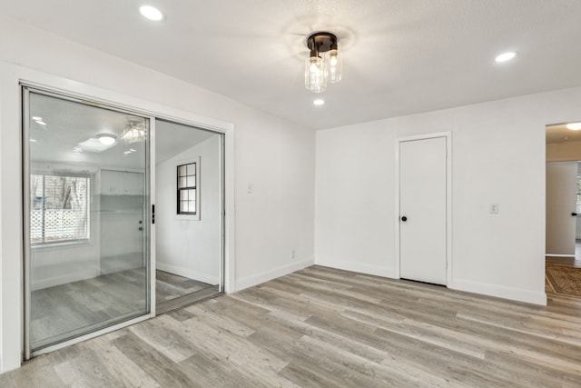 spare room featuring baseboards, wood finished floors, and recessed lighting