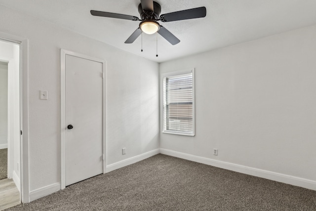 unfurnished bedroom with ceiling fan, carpet flooring, and baseboards