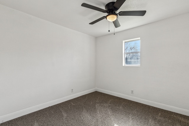 empty room featuring baseboards, dark colored carpet, and a ceiling fan