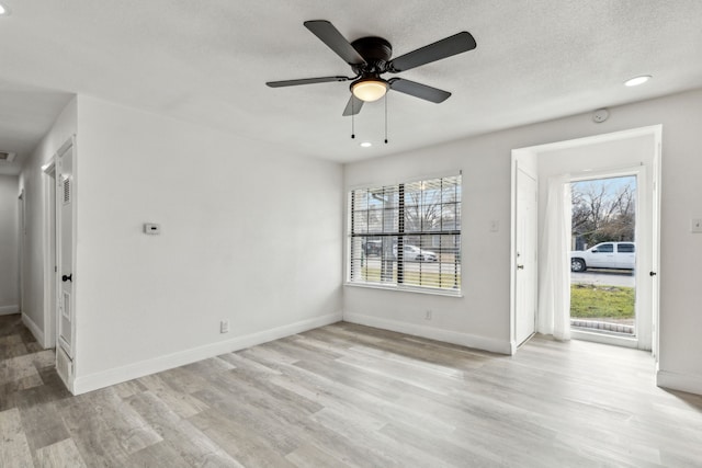 interior space featuring baseboards, ceiling fan, a textured ceiling, light wood-style floors, and recessed lighting