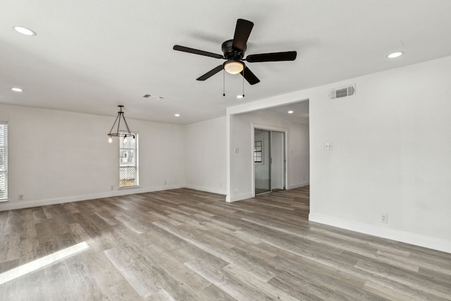 empty room with light wood-type flooring, visible vents, and baseboards