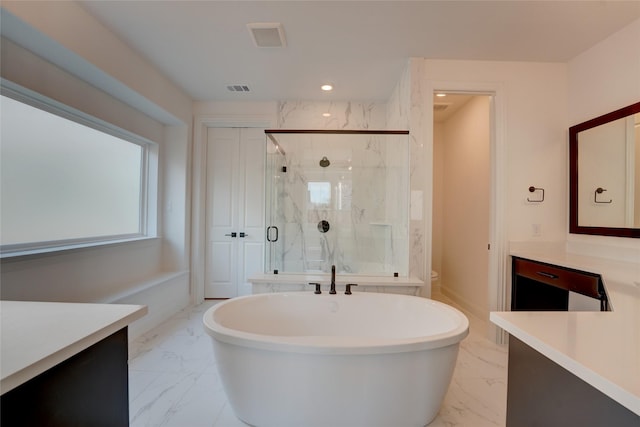 bathroom featuring marble finish floor, a marble finish shower, a soaking tub, and vanity