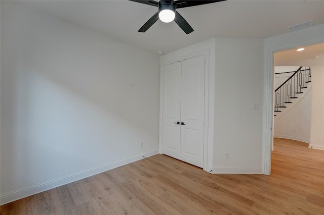 unfurnished bedroom with baseboards, visible vents, a ceiling fan, light wood-type flooring, and a closet