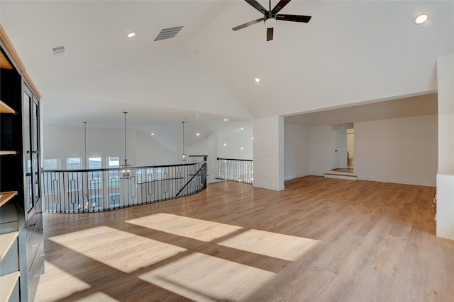 spare room with light wood-type flooring, high vaulted ceiling, and visible vents