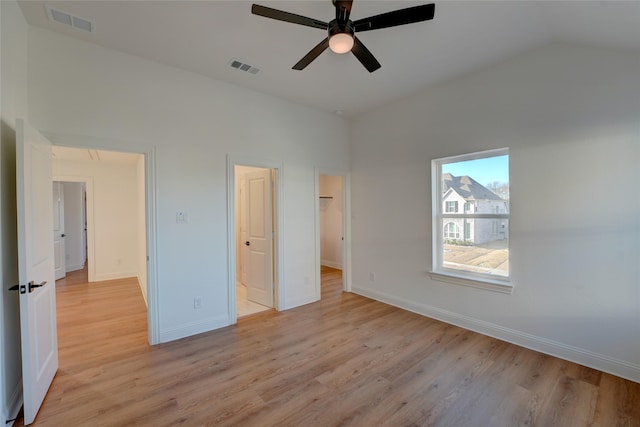 unfurnished bedroom featuring light wood-type flooring, baseboards, visible vents, and lofted ceiling