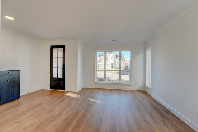 foyer entrance with ornamental molding, baseboards, and light wood finished floors