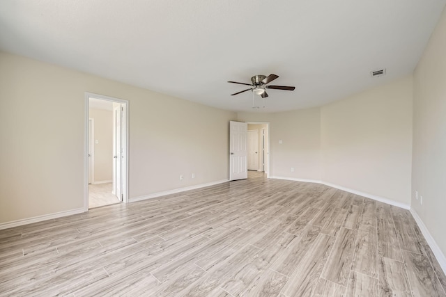 unfurnished room with light wood-style flooring, a ceiling fan, visible vents, and baseboards