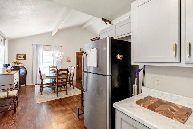 kitchen with a wealth of natural light, freestanding refrigerator, dark wood-type flooring, and vaulted ceiling with beams