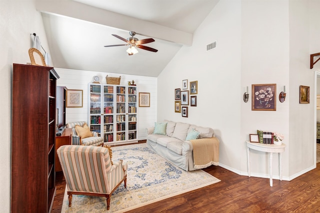 living area with baseboards, visible vents, a ceiling fan, lofted ceiling with beams, and wood finished floors