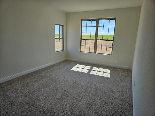 carpeted spare room featuring baseboards