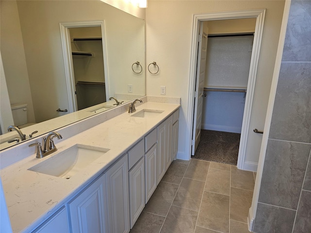 bathroom featuring a sink and a walk in closet