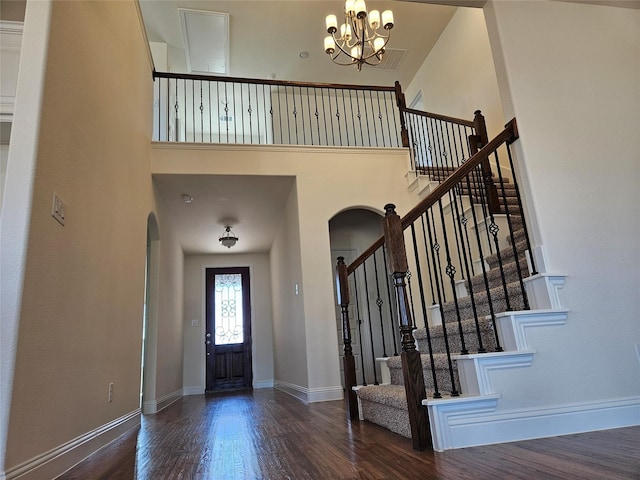 foyer with a high ceiling, baseboards, and wood finished floors