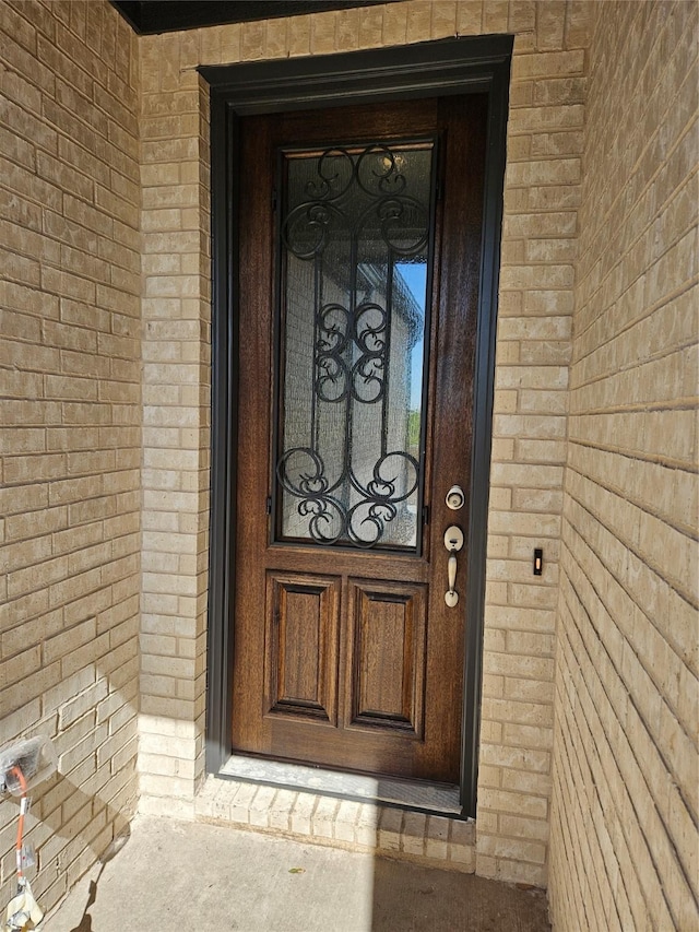 view of exterior entry featuring brick siding