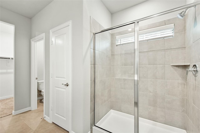 full bathroom with baseboards, a shower stall, toilet, and tile patterned floors