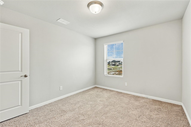 carpeted empty room featuring baseboards and visible vents