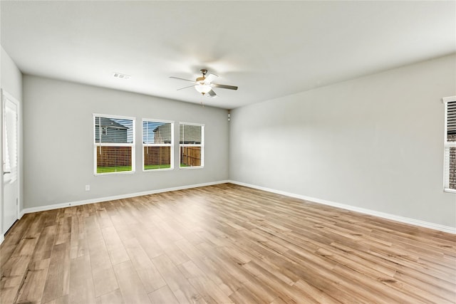 empty room with ceiling fan, baseboards, visible vents, and light wood-style floors