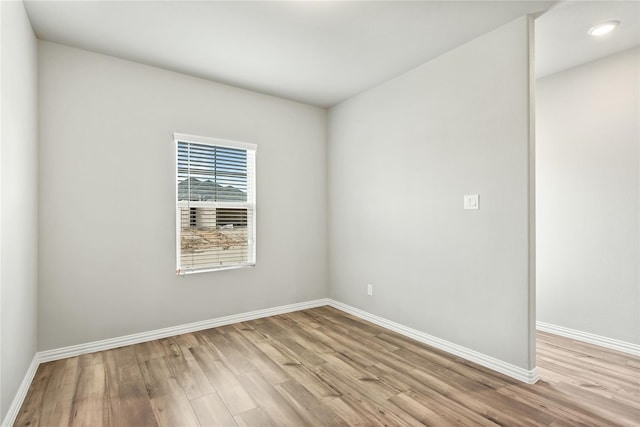 empty room featuring recessed lighting, baseboards, and wood finished floors