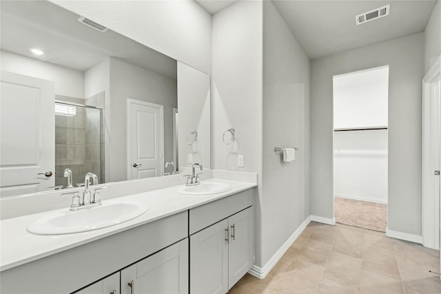 full bath with visible vents, a sink, a shower stall, and double vanity