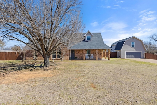 view of front of house featuring brick siding, an outdoor structure, fence, a gambrel roof, and a front yard