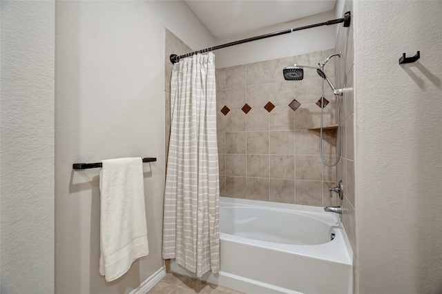 bathroom featuring shower / bathtub combination with curtain, tile patterned flooring, and a textured wall