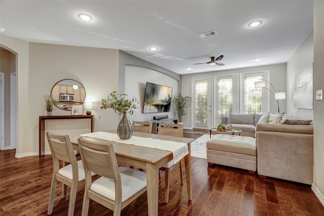 dining space with dark wood-style floors, arched walkways, recessed lighting, visible vents, and baseboards