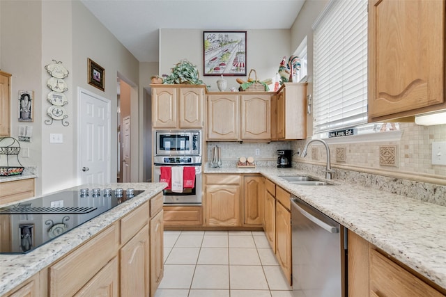 kitchen with backsplash, light brown cabinetry, appliances with stainless steel finishes, light tile patterned flooring, and a sink