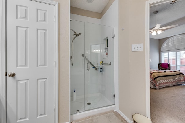 bathroom with a ceiling fan, a shower stall, a textured ceiling, and ensuite bathroom