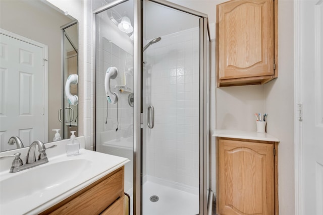 bathroom with a shower stall and vanity