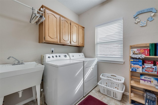 clothes washing area with light tile patterned floors, a sink, cabinet space, and washer and dryer