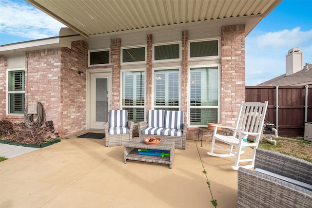 view of patio featuring outdoor lounge area and fence