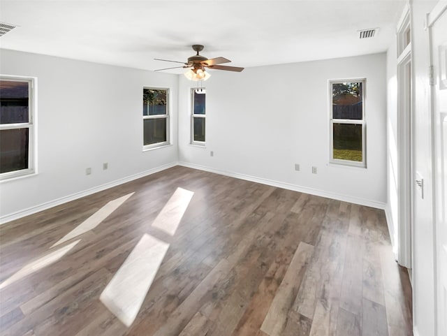 unfurnished room with visible vents, ceiling fan, baseboards, and wood finished floors