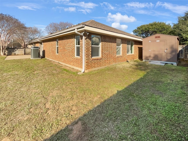 view of home's exterior with an outbuilding, brick siding, a yard, a storage shed, and fence