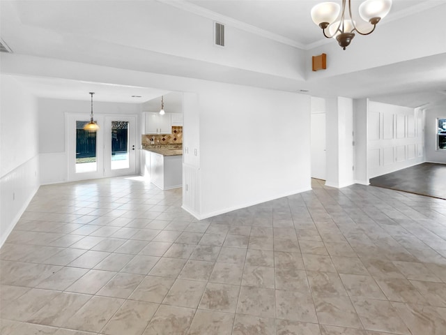 unfurnished living room featuring ornamental molding, a chandelier, visible vents, and light tile patterned floors