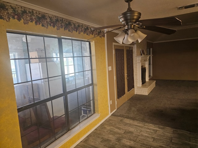 hallway featuring visible vents, crown molding, and wood finished floors