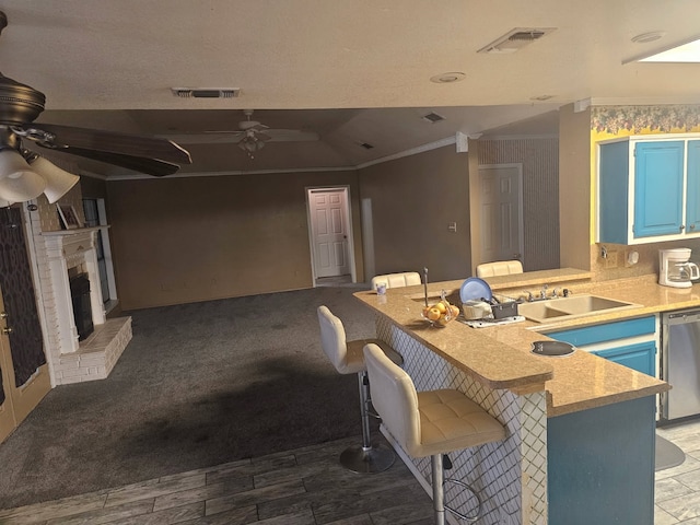 kitchen with visible vents, dishwasher, ceiling fan, a breakfast bar area, and blue cabinets