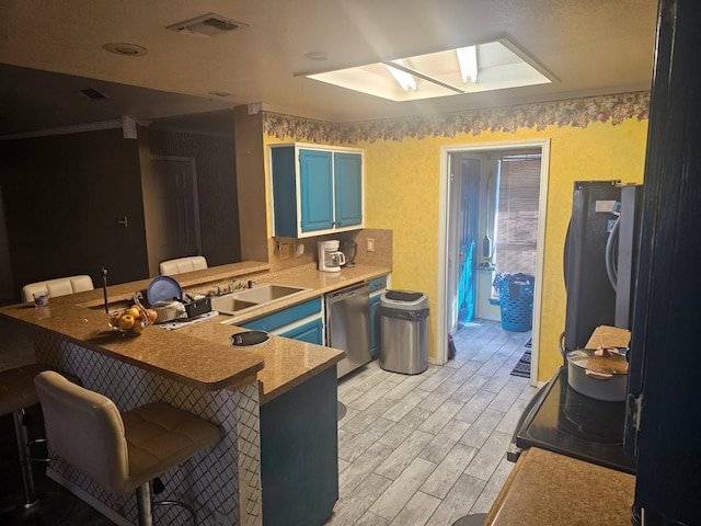 kitchen featuring light wood-style flooring, a peninsula, a breakfast bar, stainless steel dishwasher, and blue cabinetry