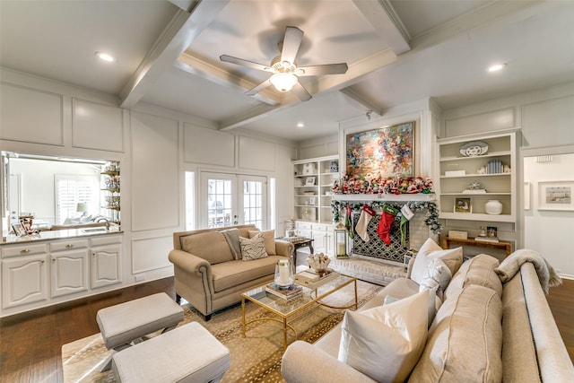 living room featuring french doors, beam ceiling, dark wood-style floors, and a decorative wall